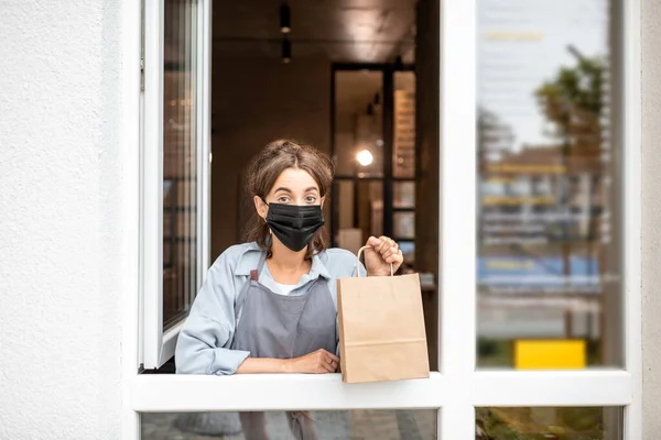 Woman with food to take away in the shop window — Stock Photo, Image