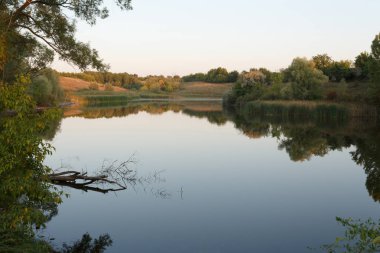 Gün batımında sakin gölet, yaz