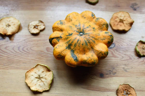 Cosecha de calabazas amarillas con manzanas secas cortadas sobre la mesa — Foto de Stock