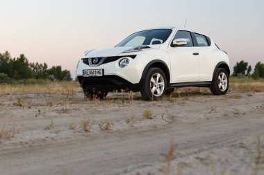 Novoselivka, Dnipropetrovsk bölgesi, Ukrayna - Temmuz 02, 2020: Nissan Juke 2019 Alacakaranlıktaki kırsal yol yakınlarındaki beyaz renk