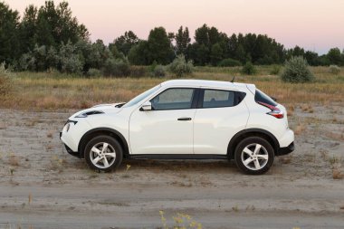 Novoselivka, Dnipropetrovsk bölgesi, Ukrayna - Temmuz 02, 2020: Nissan Juke 2019 Alacakaranlıktaki kırsal yol yakınlarındaki beyaz renk