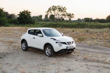 Novoselivka, Dnipropetrovsk bölgesi, Ukrayna - Temmuz 02, 2020: Nissan Juke 2019 Alacakaranlıktaki kırsal yol yakınlarındaki beyaz renk