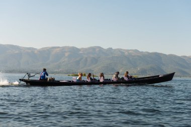Inle Lake, Myanmar - 28 Kasım 2018: Inle gölünde seyreden turistlerle yerel ahşap teknenin yatay resmi, Myanmar