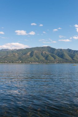 Sakin suların dikey resmi ve Inle gölünde bulunan dağların güzel görünümü, Myanmar