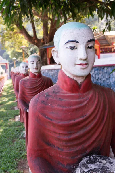 Vertical picture of monks statues, symbol of Offering at Kaw Ka Thaung Cave, located close to Hpa-An, Myanmar