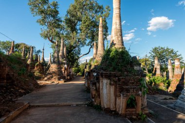 Mavi gökyüzü gününde Inle Gölü'nde bulunan Indein tapınağında yerel bitki örtüsü ile antik stupas yatay resim, Myanmar