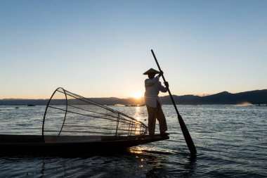 Inle Lake, Myanmar - 30 Kasım 2018: İnle Gölü'nde gün batımını zıt kürekli ve geleneksel net siluetli birmanyabalıkçılarının yatay resmi, Myanmar