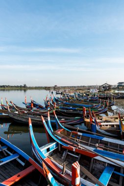 Mandalay, Myanmar - 03 Aralık 2018: Myanmar'ın turistik bir cazibe merkezi olan U Bein Köprüsü'ne yakın birçok renkli ahşap teknenin dikey resmi