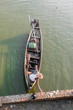 Mandalay, Myanmar - 03 Aralık 2018: Myanmar'ın Mandalay bölgesinde bulunan U Bein Köprüsü'nün altında güneşli bir günde teknenin içinde yerel birmanyabalıkçılarının dikey resmi