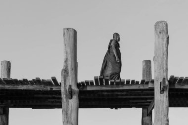 Mandalay, Myanmar - 03 Aralık 2018: Myanmar'ın ikonik turistik merkezi olan ahşap U Bein Köprüsü'nde yürüyen birmanyalı Budist rahiplerin siyah beyaz resmi