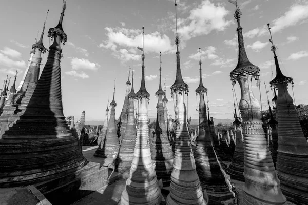 Black and white picture of beautiful old stupas at Indein temple located in Inle Lake during blue sky day, Myanmar