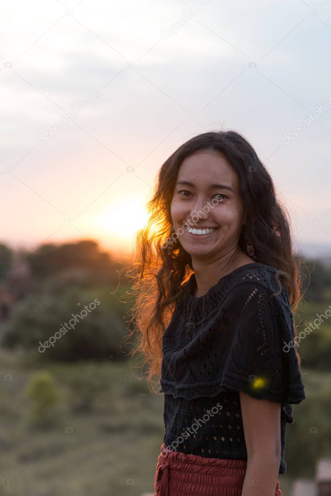 Vertical picture of happy asian eyes model posing during sunset time in Bagan, Myanmar
