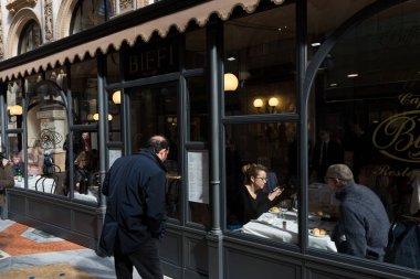 MILAN, İtalya - 16 Mart 2018: Milano, İtalya 'daki eski bir alışveriş merkezi olan Galleria Vittorio Emanuele II' deki restoranın yatay resmi