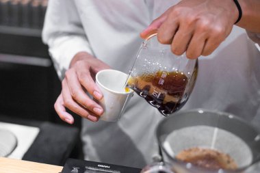 TOKYO, JAPAN- 27 Ekim 2024: Tokyo 'nun orta kesimindeki Mameya kahve dükkanında filtrelenmiş kahvenin bir fincanda servis edilişinin yatay resmi