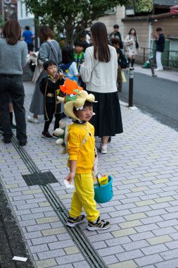 TOKYO, JAPONYA - 27 Ekim 2024 - Japon çocuğun Tokyo 'daki Omotesando Cadılar Bayramı için giyinmiş dikey fotoğrafı, Harajuku mahallesinde her yıl düzenlenen bir etkinlik..