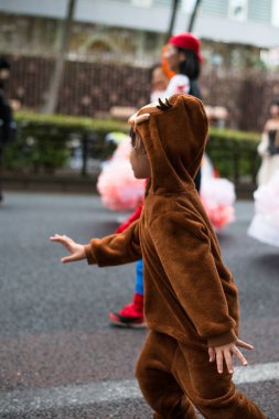 TOKYO, JAPONYA - 27 Ekim 2024 - Tokyo 'daki Omotesando Cadılar Bayramı' nda cadılar bayramı kostümü giymiş Japon bir çocuğun dikey fotoğrafı, Harajuku mahallesinde her yıl düzenlenen bir etkinlik..