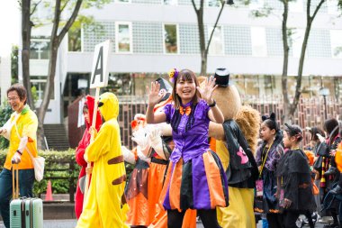 TOKYO, JAPAN - 27 Ekim 2024 - Tokyo 'daki Omotesando Cadılar Bayramı' nda tipik Cadılar Bayramı kıyafetlerini giymiş bir grup mutlu Japon 'un yatay fotoğrafı, Harajuku Mahallesi' nde her yıl düzenlenen bir etkinlik..