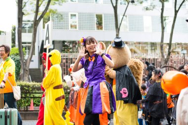 TOKYO, JAPONYA - 27 EKİM, 2024 - Tokyo 'daki Omotesando Cadılar Bayramı' nda tipik Cadılar Bayramı kıyafetlerini giymiş gülümseyen Japon kadınının yatay resmi..