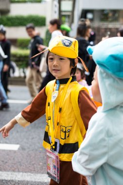 TOKYO, JAPONYA - 27 Ekim 2024 - Tokyo 'daki Omotesando Cadılar Bayramı Geçidi' nde her yıl düzenlenen Harajuku Mahallesi 'nde bulunan mutlu Japon çocuğun dikey portresi.
