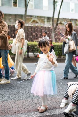 TOKYO, JAPONYA - 27 Ekim 2024 - Tokyo 'daki Omotesando Cadılar Bayramı Geçidi' ndeki tatlı Japon kızın dikey resmi, Harajuku mahallesinde her yıl düzenlenen bir etkinlik..