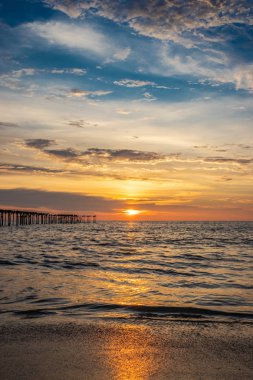 Deniz suyunun üzerindeki bulutların gün batımı rengi