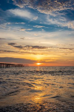 Deniz suyunun üzerindeki bulutların gün batımı rengi