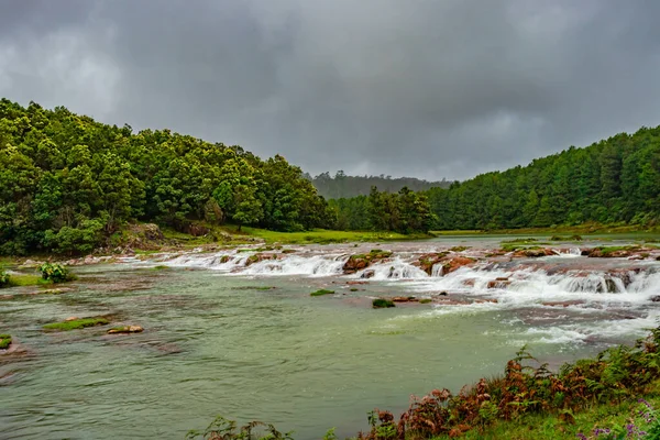Kırmızı kaya ve yeşil yemyeşil orman düz açı görüntülü şelale Güney Hindistan 'daki Ooty Tamilnadu Gölü' nde çekilmiştir. Güney Hindistan 'ın güzel manzarasını gösteriyor..