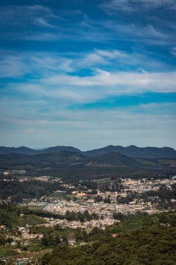 Dağ sırası ve tepeden gündüz görüntüsü ile şehir manzarası Doddabetta Peak Ooty India 'dan alınmıştır. Ooty City 'nin arka plandaki kuş bakışı görüntüsünü gösteriyor..