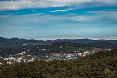 Dağ sırası ve tepeden gündüz görüntüsü ile şehir manzarası Doddabetta Peak Ooty India 'dan alınmıştır. Ooty City 'nin arka plandaki kuş bakışı görüntüsünü gösteriyor..