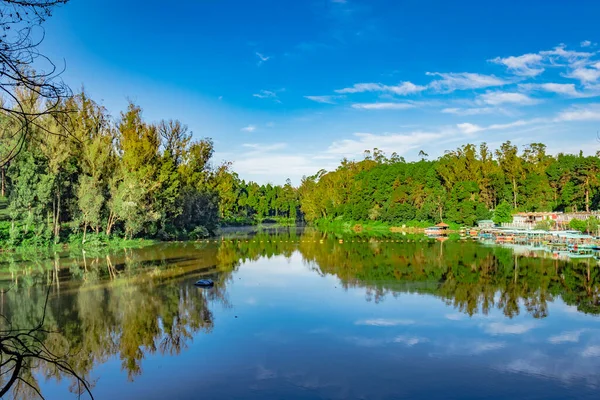 Ooty Gölü Tamilnadu Güney Hindistan 'da yeşil orman suyu yansıması ve parlak mavi gökyüzü ile sabah görüntüsü alınır. Güney Hindistan 'ın güzel manzarasını gösteriyor..