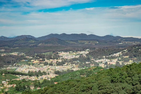 Dağ sırası ve tepeden gündüz görüntüsü ile şehir manzarası Doddabetta Peak Ooty India 'dan alınmıştır. Ooty City 'nin arka plandaki kuş bakışı görüntüsünü gösteriyor..