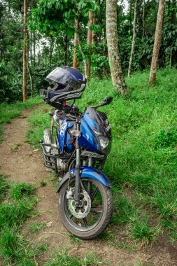 Ormanın uzak patikalarına park etmiş motosiklet yeni yerler keşfetme sevgisini gösteriyor. Görüntü, wayanad kerala Hindistan 'da 10 Mayıs 2020' de çekilmiştir..