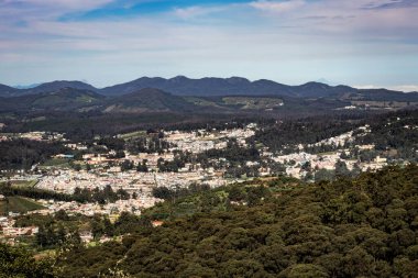 Dağ sırası ve tepeden gündüz görüntüsü ile şehir manzarası Doddabetta Peak Ooty India 'dan alınmıştır. Ooty City 'nin arka plandaki kuş bakışı görüntüsünü gösteriyor..