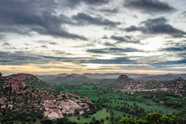 Şafak vakti muhteşem gökyüzü olan dağ, Matanga Hill hampi karnataka Hindistan 'da çekildi. Buradan manzara sakin ve nefes kesici..