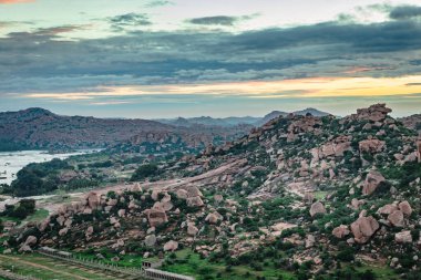 Matanga Hill hampi karnataka Hindistan 'da sabah düz açıyla çekilen dramatik gökyüzü ile dağ gündoğumu alevleri. Buradan manzara sakin ve nefes kesici..