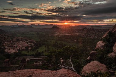 Matanga Hill hampi karnataka Hindistan 'da sabah düz açıyla çekilen dramatik gökyüzü ile dağ gündoğumu alevleri. Buradan manzara sakin ve nefes kesici..