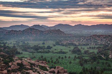 Matanga Hill hampi karnataka Hindistan 'da sabah düz açıyla kayalık dağ gündoğumu alevleri çekiliyor. Buradan manzara sakin ve nefes kesici..