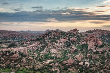 Matanga Hill hampi karnataka Hindistan 'da sabah düz açıyla çekilen dramatik gökyüzü ile dağ gündoğumu alevleri. Buradan manzara sakin ve nefes kesici..