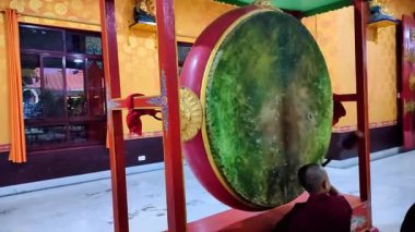 Budist keşiş akşam namazında geleneksel davul çalıyor.