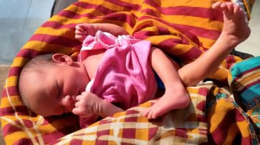 Güneşli bir günde uyurken yeni doğmuş şirin bebek yüz ifadesi bir bebeğin doğal masumiyetini gösteriyor.