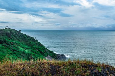 Gokarna Karnataka Hindistan 'da, dağın tepesinden dramatik bulutlarla deniz ufku görüntüsü alınır. Tepeden aşağıya Gokarna sahilinin saf güzelliğini gösteriyor..