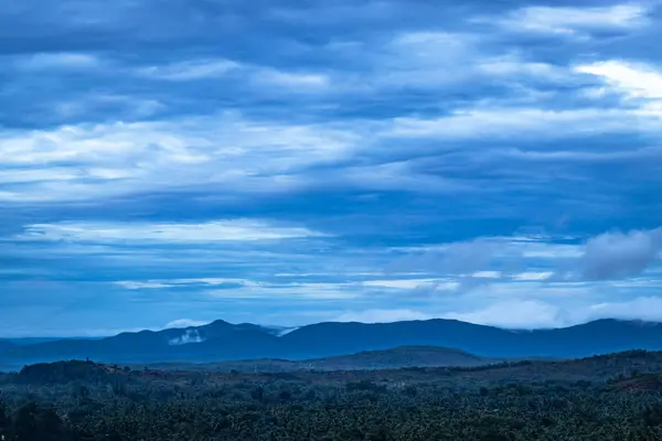 mountain top view of clouded sky with hill range image is taken at gokarna karnataka india.