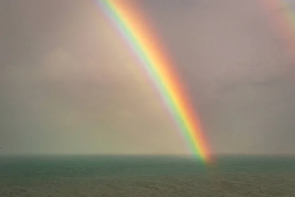 rainbow colorful above sea horizon at dawn image is taken at gokarna karnataka india. it is showing the colorful art of nature.