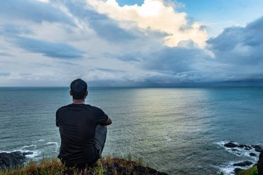 Gokarna Karnataka Hindistan 'da sabah görüntüsünde inanılmaz manzara ve deniz ufkuyla meditasyon yapan bir adam çekiliyor. Buradan manzara el değmemiş ve büyüleyici..