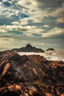 Sahil Gokarna Karnataka Hindistan 'da sabah düz açılı dalgalarla kayalık sahil sahili görüntüsü çekiliyor. Gokarna 'nın en iyi plajlarından biri..