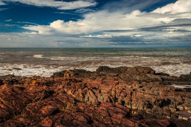 Sahil Gokarna Karnataka Hindistan 'da sabah düz açılı dalgalarla kayalık sahil sahili görüntüsü çekiliyor. Gokarna 'nın en iyi plajlarından biri..