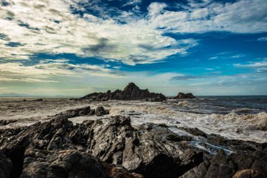 Sahil Gokarna Karnataka Hindistan 'da sabah düz açılı dalgalarla kayalık sahil sahili görüntüsü çekiliyor. Gokarna 'nın en iyi plajlarından biri..