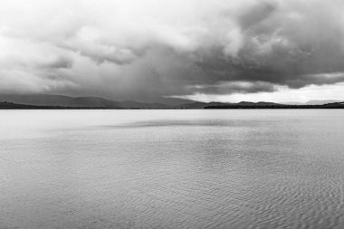 Sade göl manzarası sakin su ve dramatik gökyüzü sabah düz açıyla siyah beyaz görüntü Om plajı Gokarna Karnataka Hindistan 'da çekilmiştir..