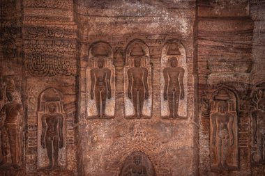 badami cave sculptures of jain gods carved on walls ancient stone art in details image is taken at badami karnataka india. it is unesco heritage site and place of amazing chalukya dynasty sotne art. clipart