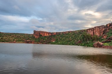 Sabahları dağlarla çevrili antik tapınakla çevrili göl, Badami Karnataka Hindistan 'ında Agastya Tirtha kıyılarındaki Bhutanatha Tapınağı' nın güzelliğini gösteriyor..